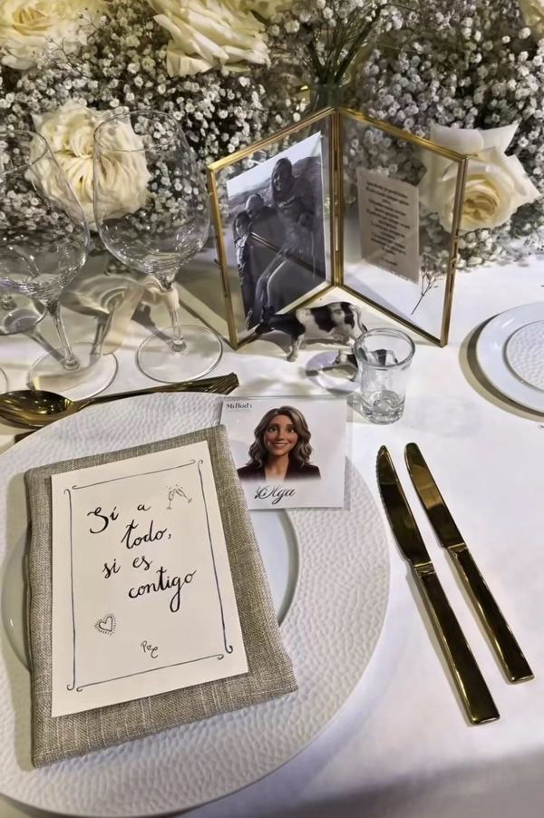 Ilustración personalizada de la invitada Olga colocada como sitio de mesa junto a la decoración floral de la boda