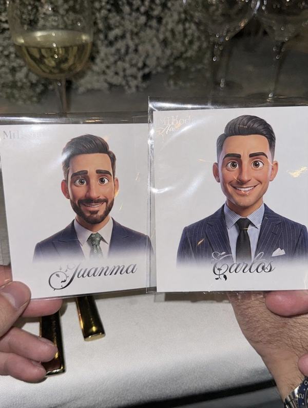 Ilustraciones personalizadas de los invitados Juanma y Carlos sujetas en la mano durante la boda