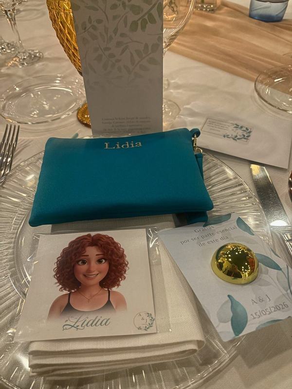 Ilustración personalizada de la invitada Lidia junto a su neceser bordado en la mesa de la boda